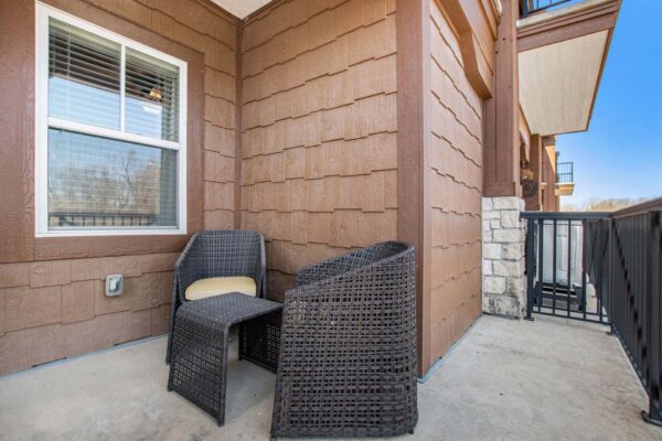 Highlands Lodge apartment balcony with outdoor furniture and metal railing.