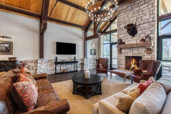 Highlands Lodge clubhouse lounge with plush seating and large stone fireplace.
