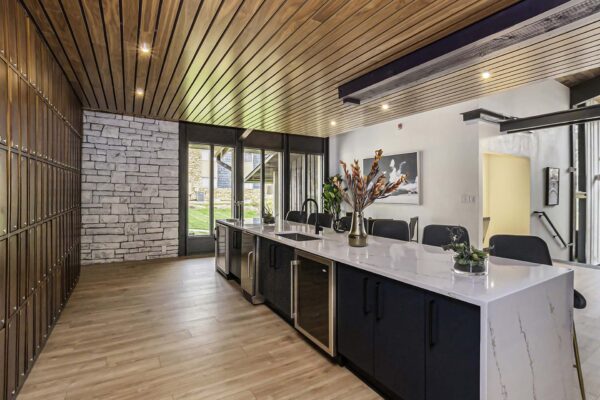 Kenilworth apartments clubroom with elegant bar, wine fridges and storage, and vases with flowers.