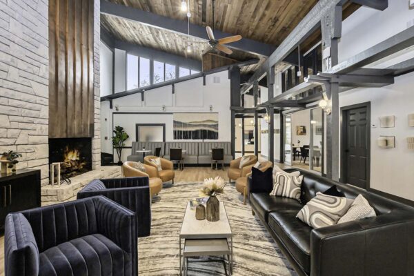 Kenilworth apartments clubhouse with plush seating, large metal fireplace, and vaulted ceilings.