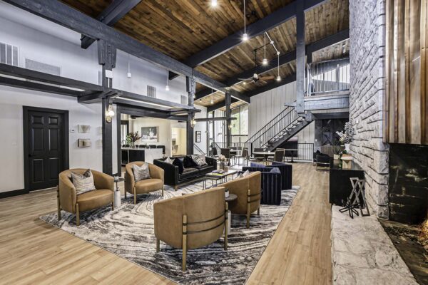 Kenilworth apartments clubhouse with plush seating, vaulted ceilings, and stairway to mezzanine.