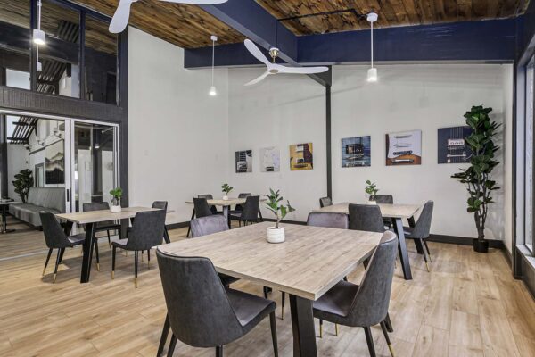 Kenilworth apartments community kitchen with large tables, vaulted ceilings, and pictures of guitars.