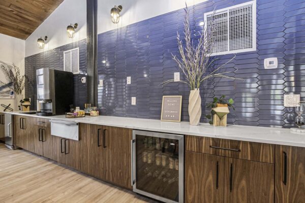 Kenilworth apartments community kitchen with wood style floor and cabinets, stainless steel appliances, and tiled backsplash.