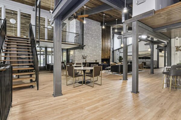 Kenilworth apartments clubhouse with ample seating, fireplace, stairs to mezzanine, and vaulted ceilings.
