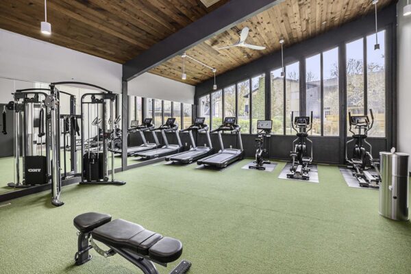 Kenilworth apartments fitness center with cardio machines, weight equipment, and large windows.