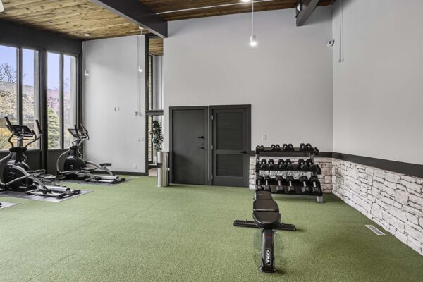 Kenilworth apartments fitness center with cardio machines, weight equipment, and large windows.