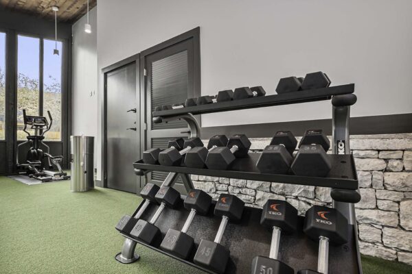 Kenilworth apartments fitness center with cardio machines, weight equipment, and large windows.