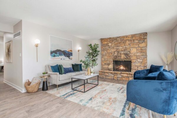 Kenilworth apartment living room with wood style floor, stone fireplace, plush seating, and designer lighting.