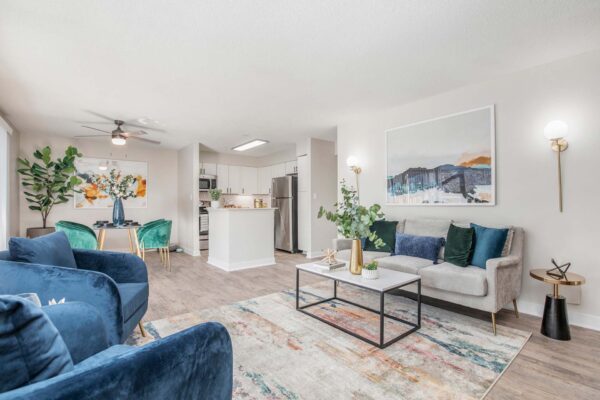Kenilworth apartment living room with wood style floor, pattern rug, plush seating, and designer lighting.