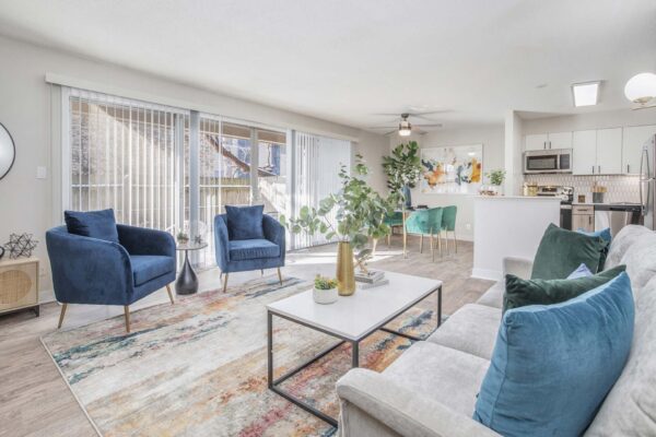 Kenilworth apartment living room with wood style floor, balcony doors, plush seating, and designer lighting.