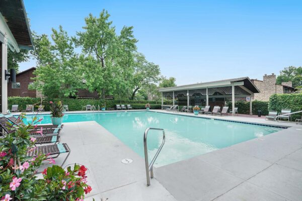 Kenilworth apartments pool area with lounge chairs and large potted plants.