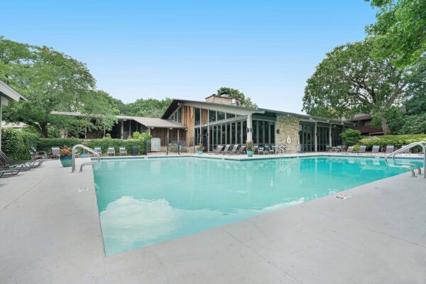 Kenilworth apartments pool area with lounge chairs and large potted plants.