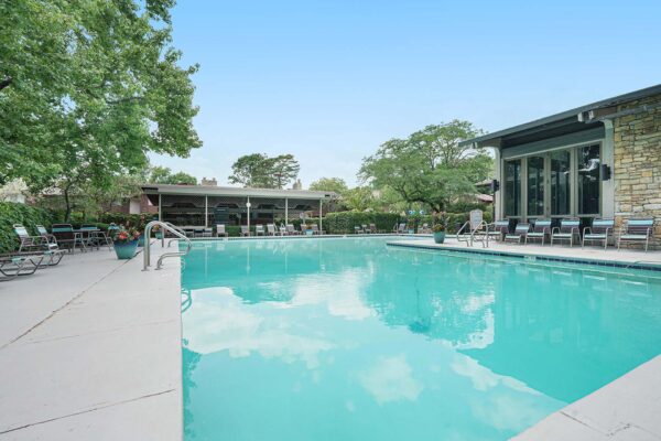 Kenilworth apartments pool area with lounge chairs and large potted plants.