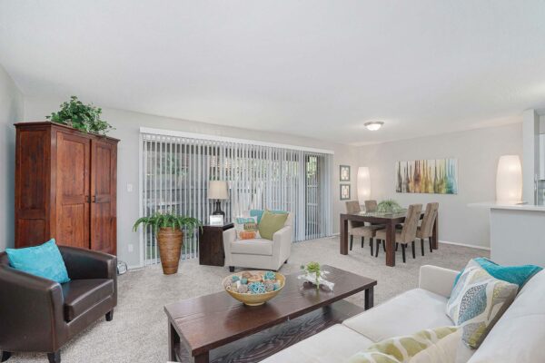 Kenilworth apartment living room with plush seating, bright decor, and balcony door.