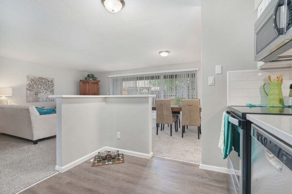 Kenilworth apartment kitchen with wood style floor, white cabinets and counters, and stainless steel appliances.