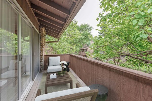 Kenilworth apartment balcony with outdoor furniture overlooking lush trees.
