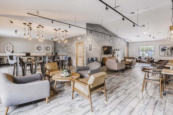 Latitude apartments clubroom with tile floors, plush seating, and vaulted ceilings.