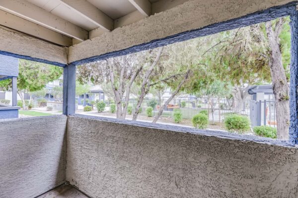 Latitude apartment balcony overlooking lush trees and bushes.