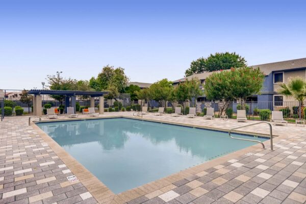 Latitude apartments pool area with lounge chairs and pergola.