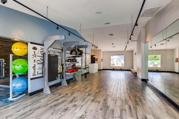 Latitude apartments fitness center with calisthenics equipment and mirror wall.