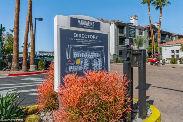 Mandarina apartments entrance with colorful flowers and directory map.
