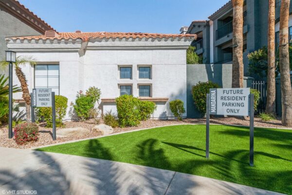 Mandarina apartment clubhouse with lush landscaping and ample parking.