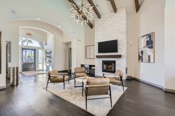 Mandarina apartments lobby with plush seating, fireplace, wall mounted TV, and designer light fixture.