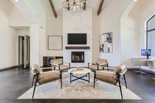 Mandarina apartments lobby with leather arm chairs, fireplace, and wall mounted TV.
