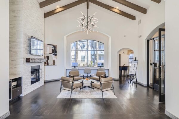 Mandarina apartments lobby with leather arm chairs, fireplace, TV, and vaulted ceilings.