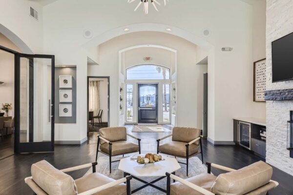 Mandarina apartments lobby with leather arm chairs, coffee table with decor, and vaulted ceilings.