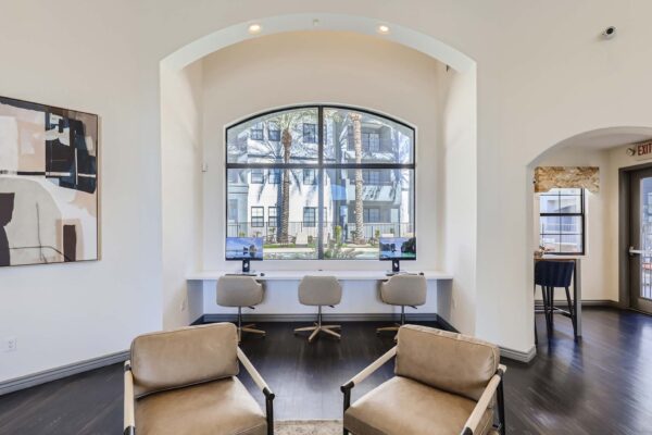 Mandarina apartments lobby with leather arm chairs, computer desks, and large windows.