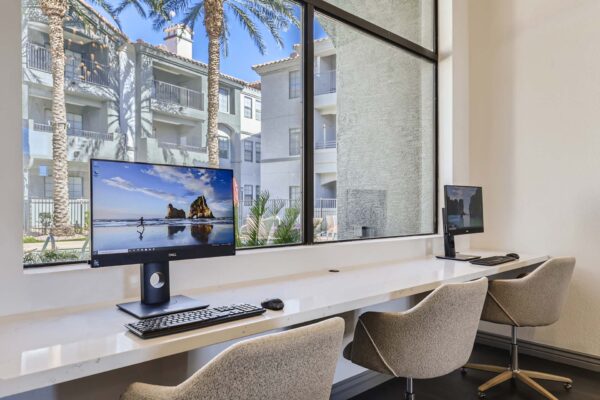 Mandarina apartments workspace with computer desks and large window.