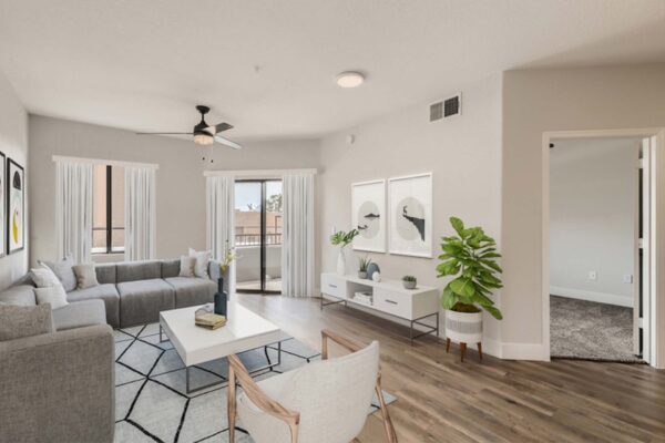 Mandarina apartment living room with wood style floor, plush seating, modern decor, and balcony door.