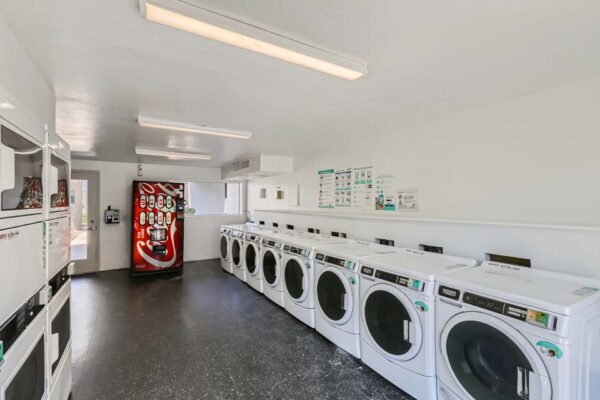 Omnia on Thomas apartments laundry room with washers, dryers, and soda machine.