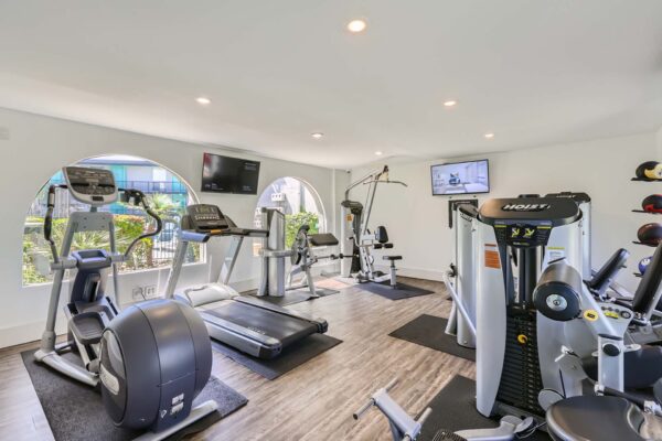 Omnia on Thomas apartments fitness center with cardio machines, weight equipment, and TV.