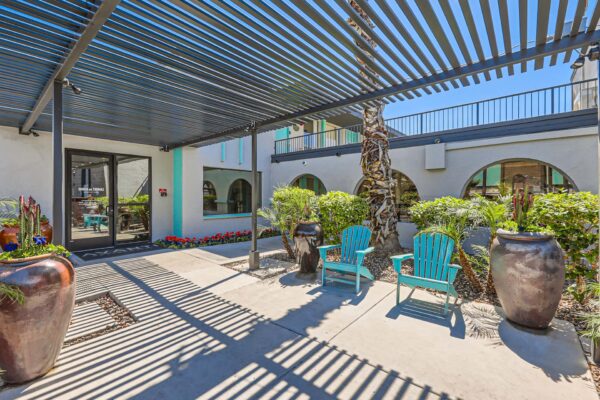 Omnia on Thomas apartments outdoor lounge with pergola, lounge chairs, and lush landscaping.