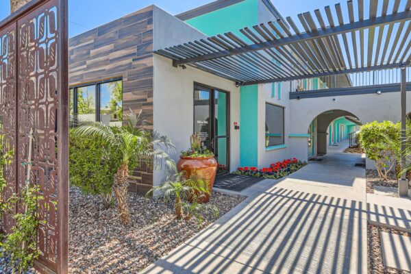 Omnia on Thomas apartments entrance with lush landscaping and pergola.