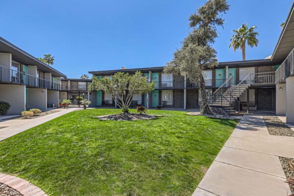 Omnia on Thomas apartments courtyard with lush green lawns and tall trees.