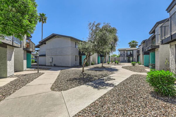 Omnia on Thomas apartments courtyard with paved walkways and rocky landscaping.