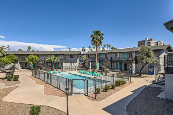 Omnia on Thomas apartments pool area with paved walkways and rocky landscaping.