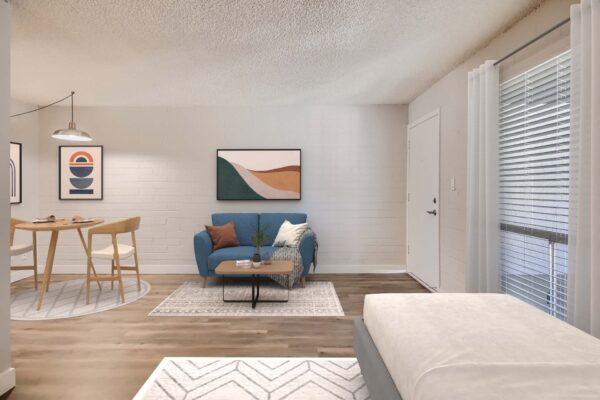 Omnia on Thomas apartment studio living space with plush bed, tall dining table with stools, and couch with pillows.