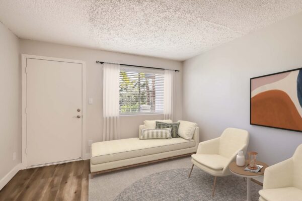 Omnia on Thomas apartment living room with plush seating, framed artwork, and large window.