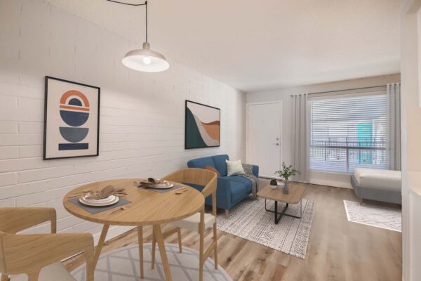 Omnia on Thomas apartment living area with wood style floor, plush seating, and wood dining table with stools.
