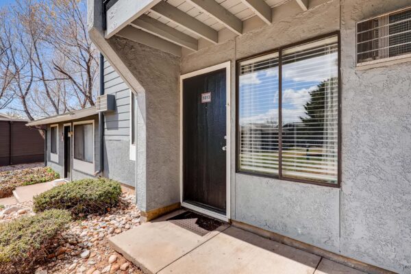 Overlook at Sunset Point apartment entrance with concrete patio and large window.