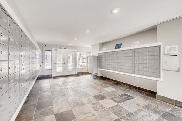 Overlook at Sunset Point apartments mail room with tile floor and gray mailboxes.