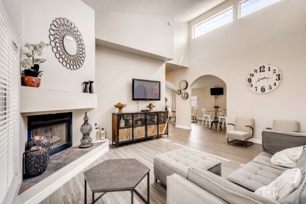 Overlook at Sunset Point apartments clubhouse with plush seating, fireplace, TV, and vaulted ceilings.
