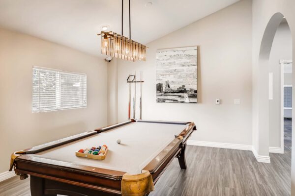 Overlook at Sunset Point apartments clubhouse with billiards table and large artwork.