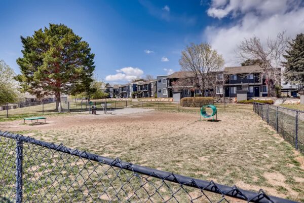 Overlook at Sunset Point apartments dog park with agility toys and metal fence.