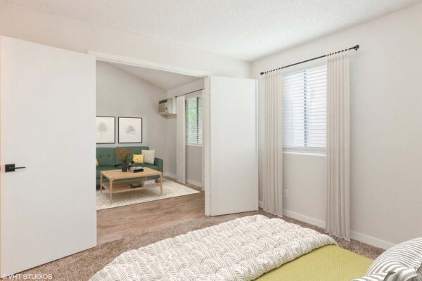 Overlook at Sunset Point apartment bedroom with carpet, plush bed, and large window.