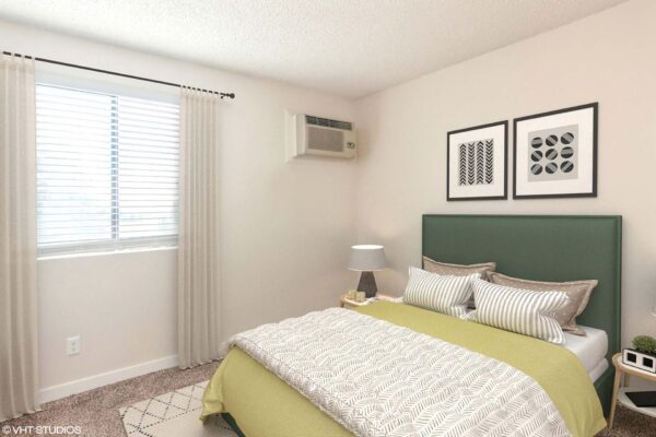 Overlook at Sunset Point apartment bedroom with carpet, plush bed with headboard, framed art, and large window.